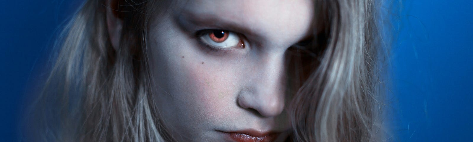 A woman with red eyes staring right at the screen.