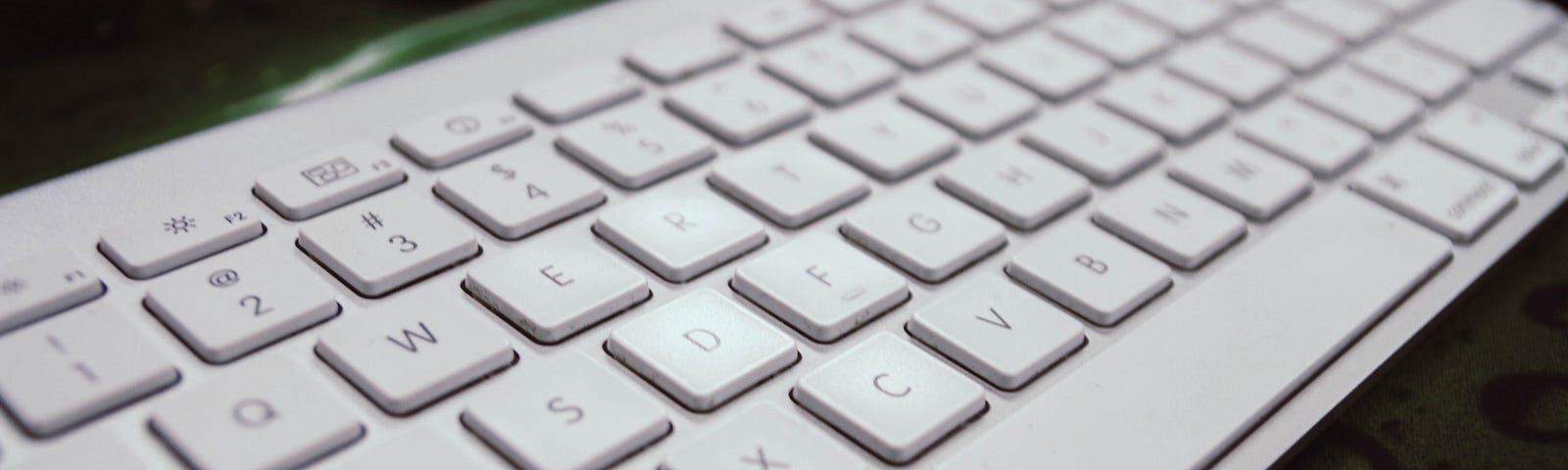 A white keyboard laid on a desk