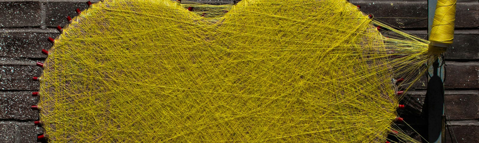 a heart woven from yellow string