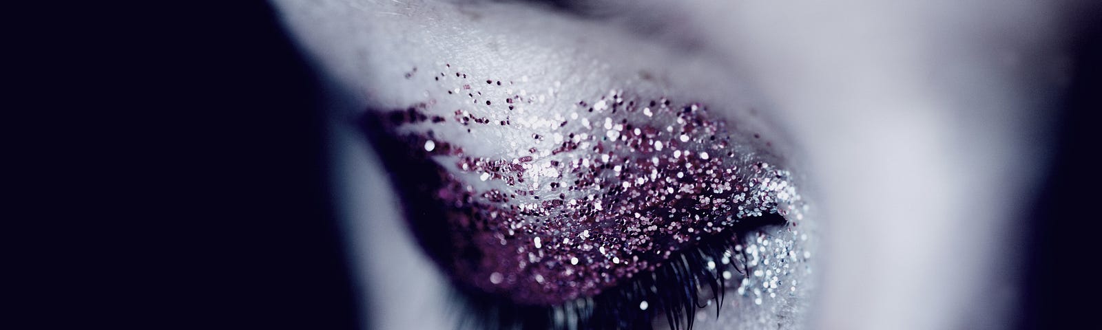 Close-up of a woman’s closed eye with glittery make-up.