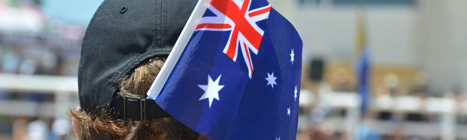 Image of a man wearing a hat with an Australian flag tucked in the back,