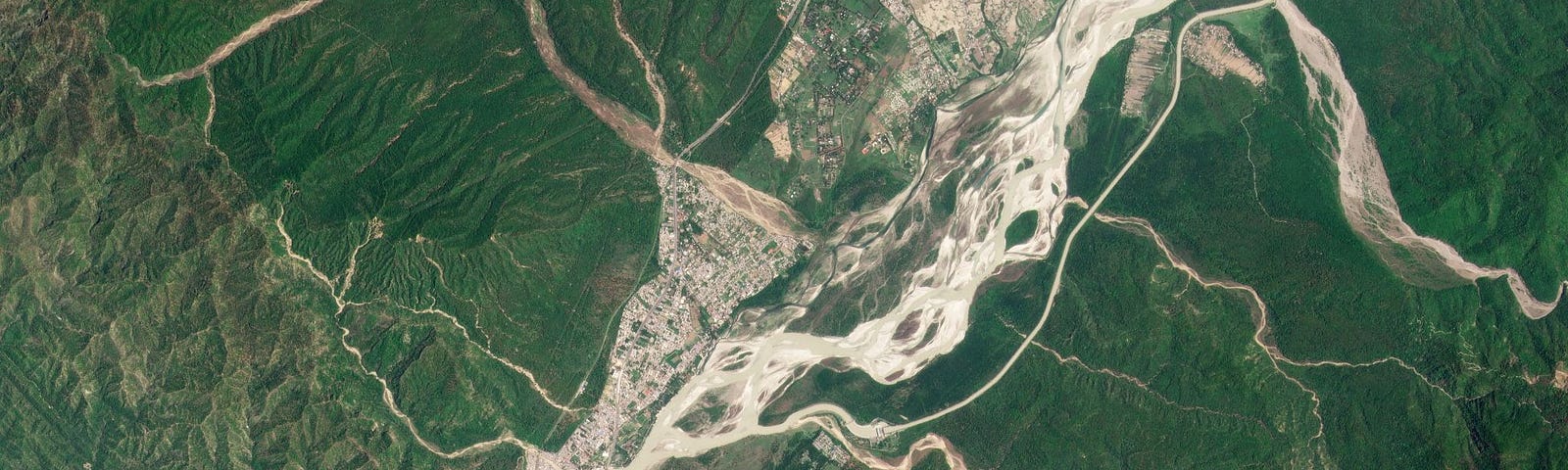 The Ganges River bisects two districts of the Rajaji National Park, alongside densely populated neighborhoods of Haridwar, India. June 2021. PlanetScope.