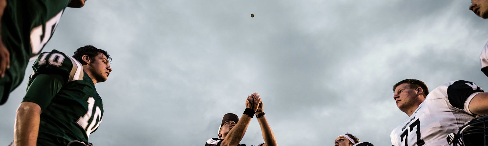 American football referee tosses a coin.