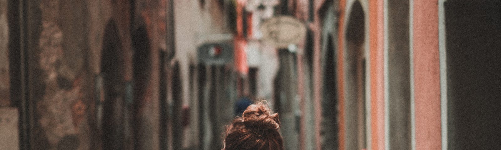 Person wearing a backpack walking in an alley