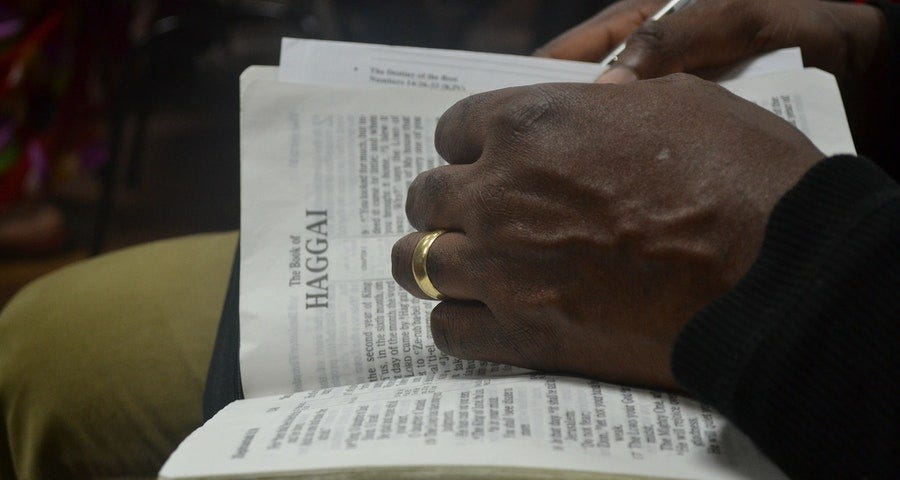 A man with an open Bible on his lap