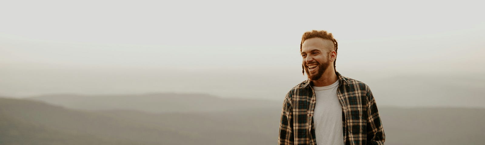 Picture showing a man happy on the cliff of a mountain.