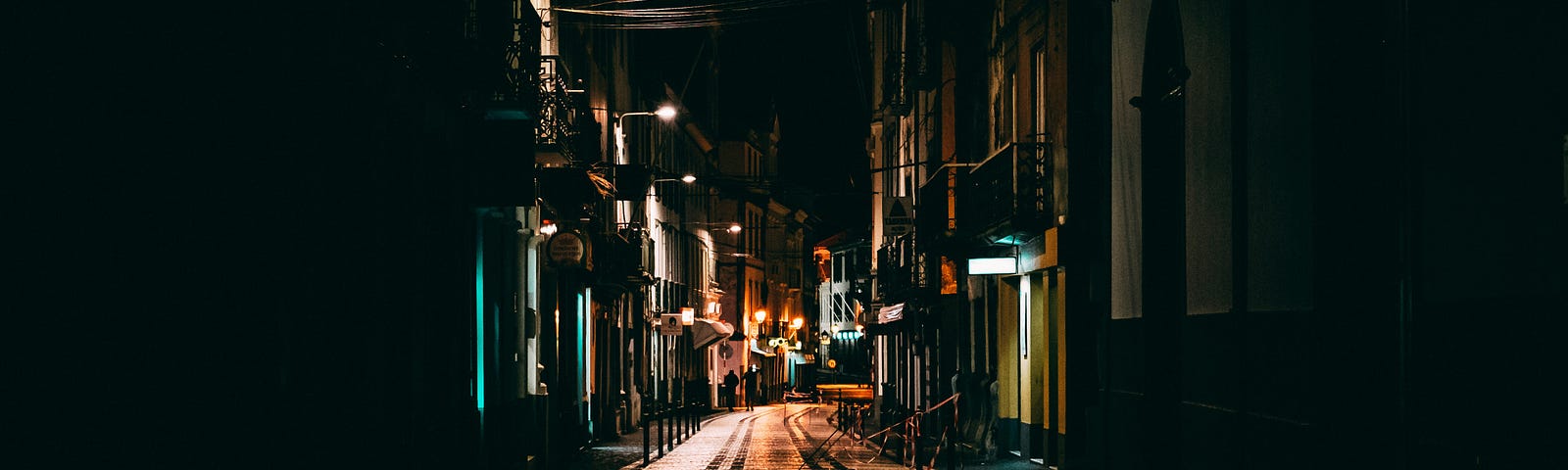 A dark alleyway at night, in the dark.