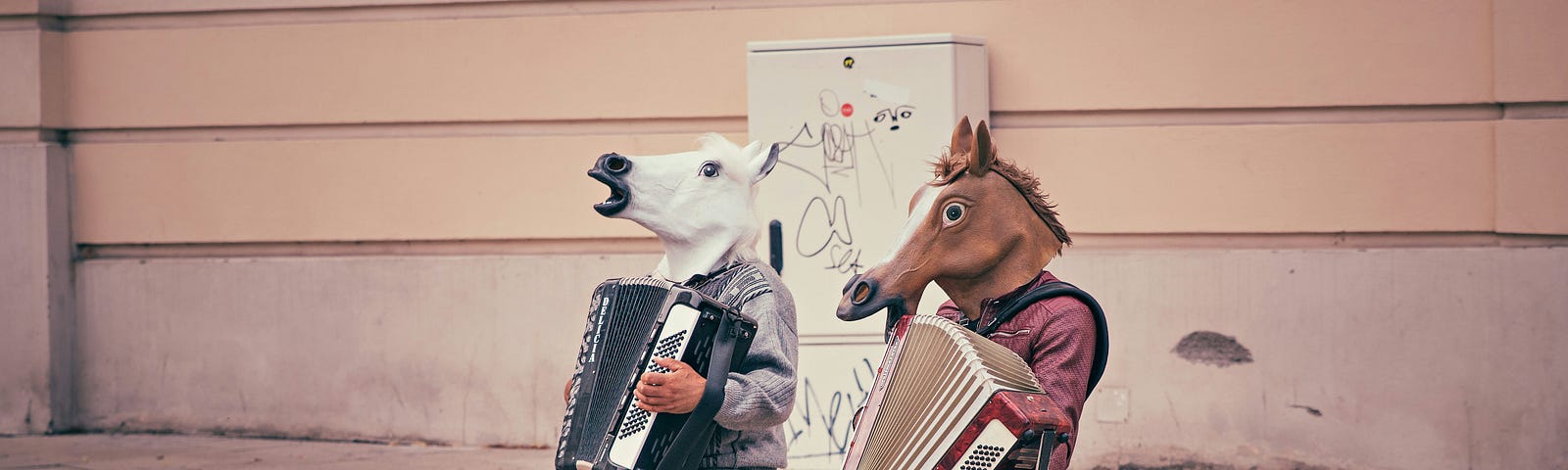 Two men playing a musical instrument on the street with horse masks on their faces.