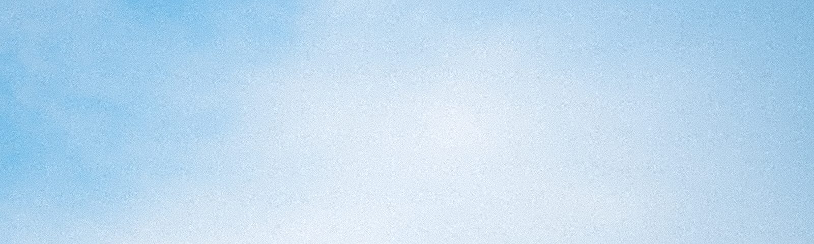 an image of the back of a yellow school bus with a blue sky seen above