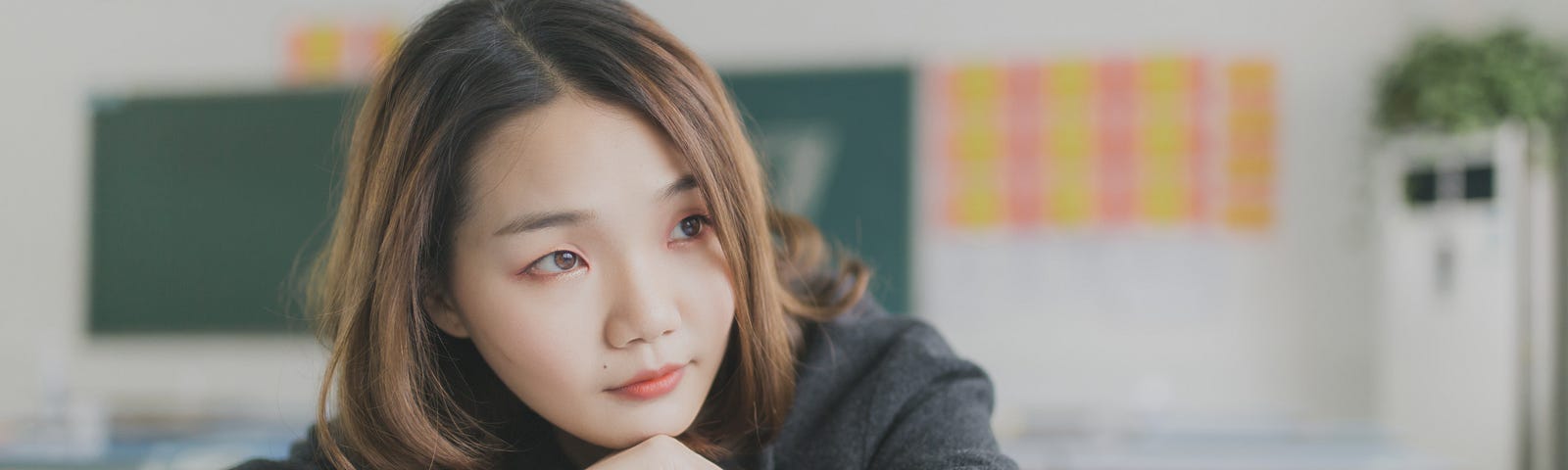 A girl in a classroom with a book under her hands