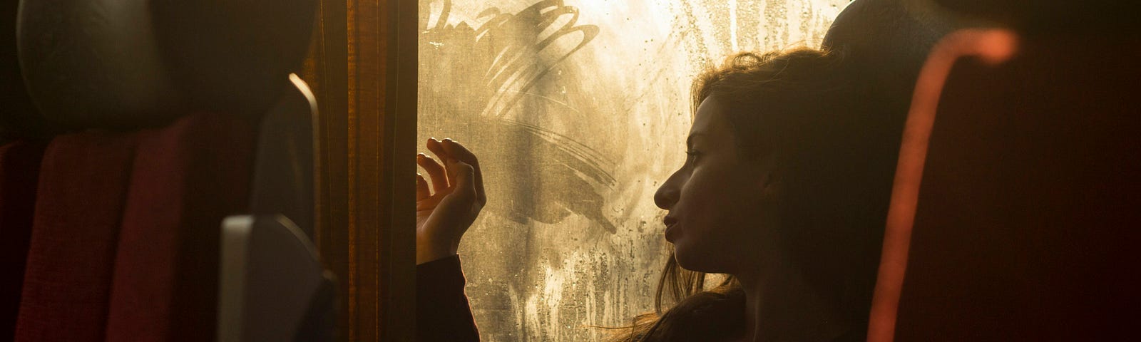 A young woman sitting by the window on the train.