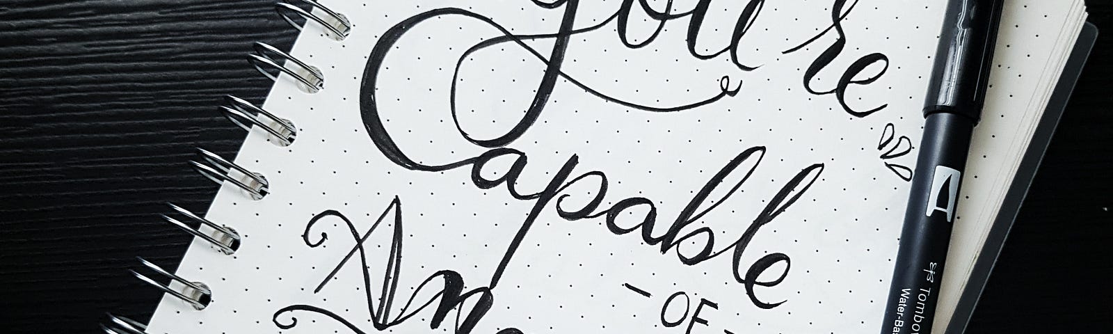 “You’re capable of amazing things” written in bold cursive on a notebook page
