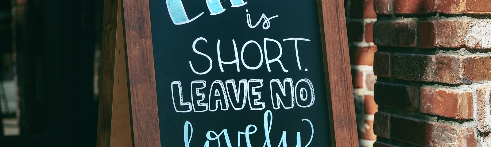 “life is short. Leave no lovely word unsaid.” Quote on a chalk board sign.