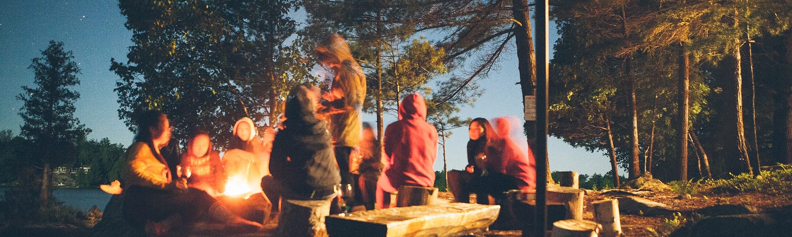 A group of hippies sitting around the campfire.