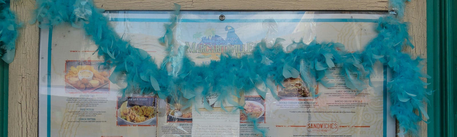 A memorial picture of Jimmy Buffett’s Margaritaville with flowers and memories left on the bottom.