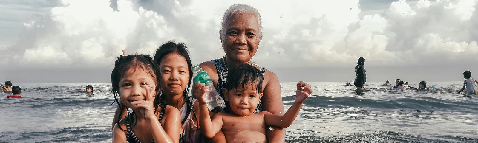 A grandmother and grandchildren bathe in the sea