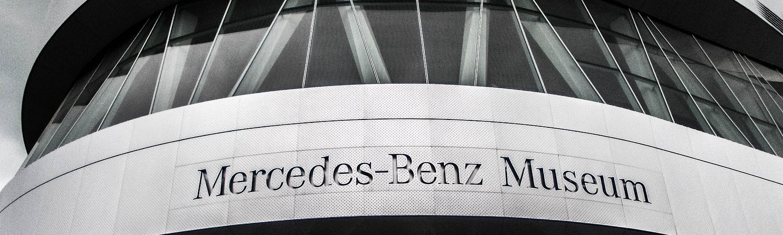Black and white pic of the front of a Mercedes-Benz Museum.