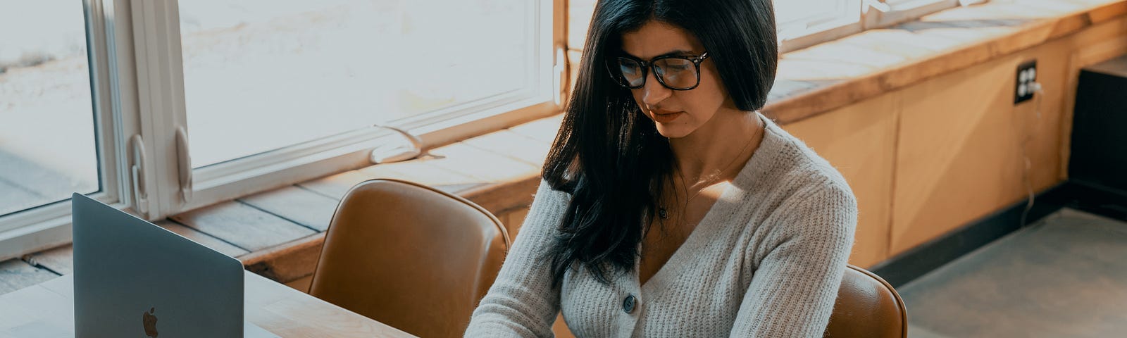 A woman in a restaurant texting on her phone.