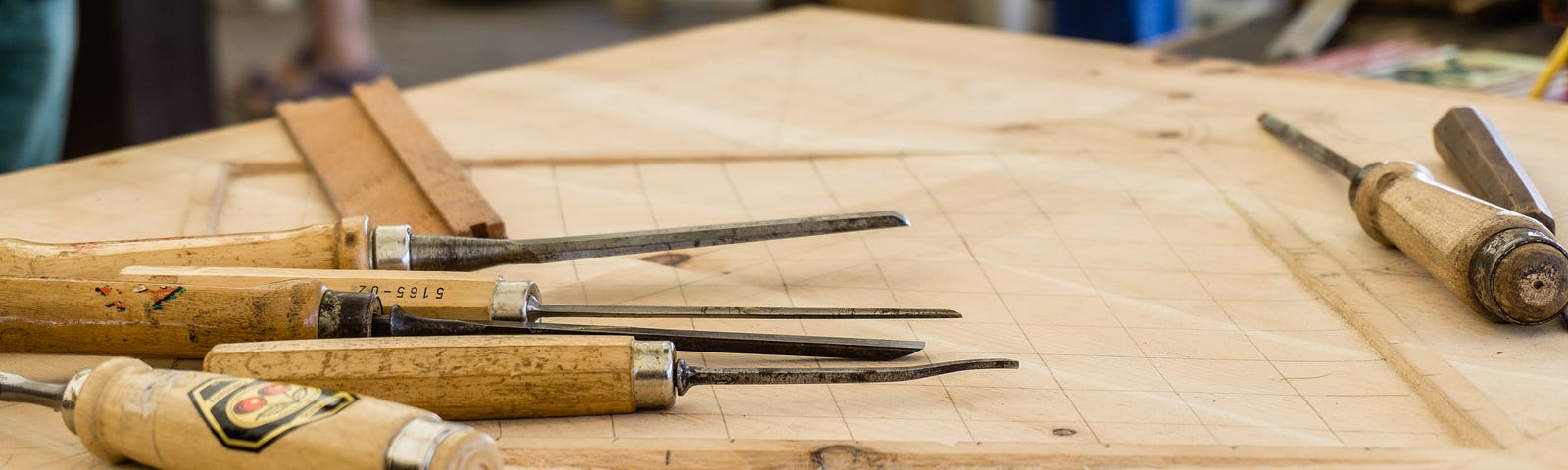 different types of chisels lying on a woodworking worktable