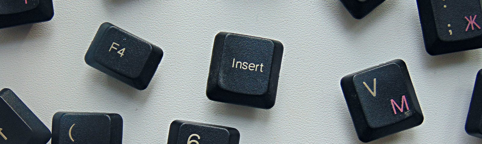 A bunch of keyboard buttons on a flat off-white surface at different angles and spaces.