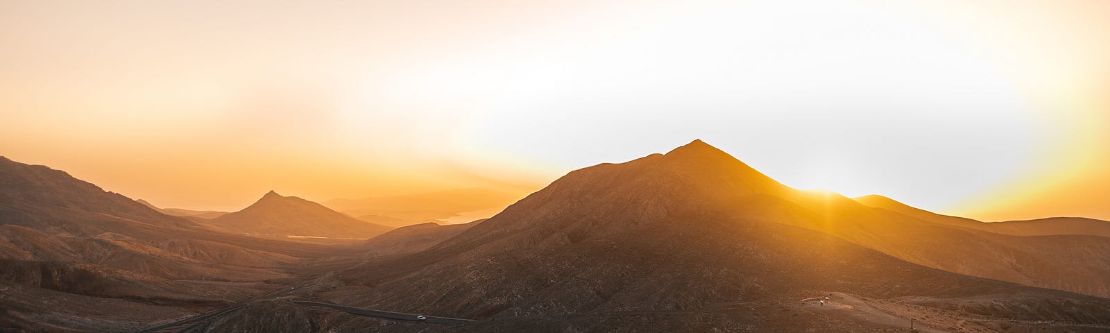 A mountain with the sun rising beyond.