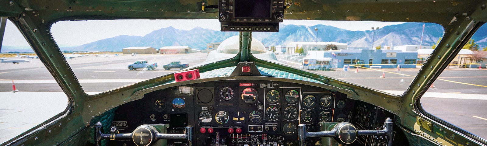 The cockpit of a jet the view is a clear blue sky and runway ahead.