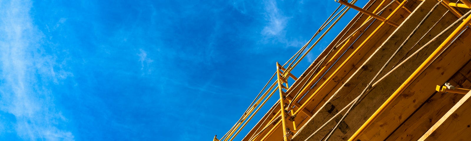 A photo of a building being erected against a deep blue sky.