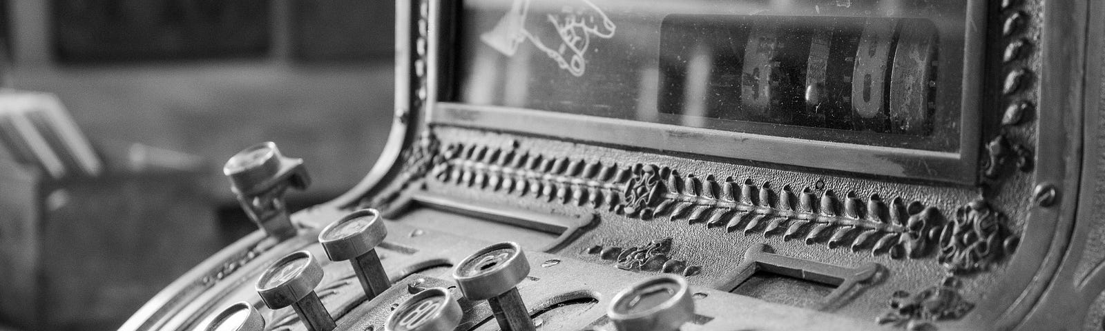 A black and white photo of an antique cash register.