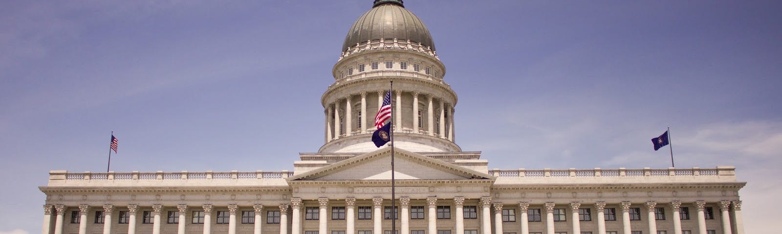 State capitol building with flags flying in front
