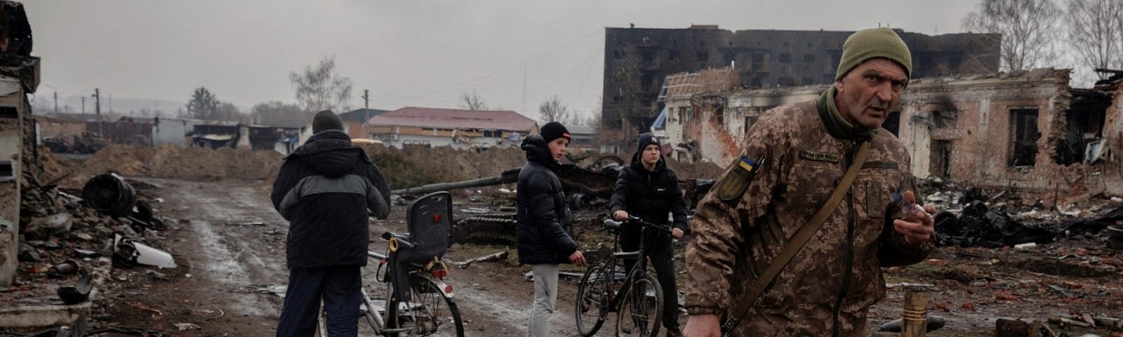 Locals walk in the demolished town center after Ukrainian forces expelled Russian troops in Trostyanets, Ukraine, March 30, 2022. Photo by Thomas Peter/Reuters