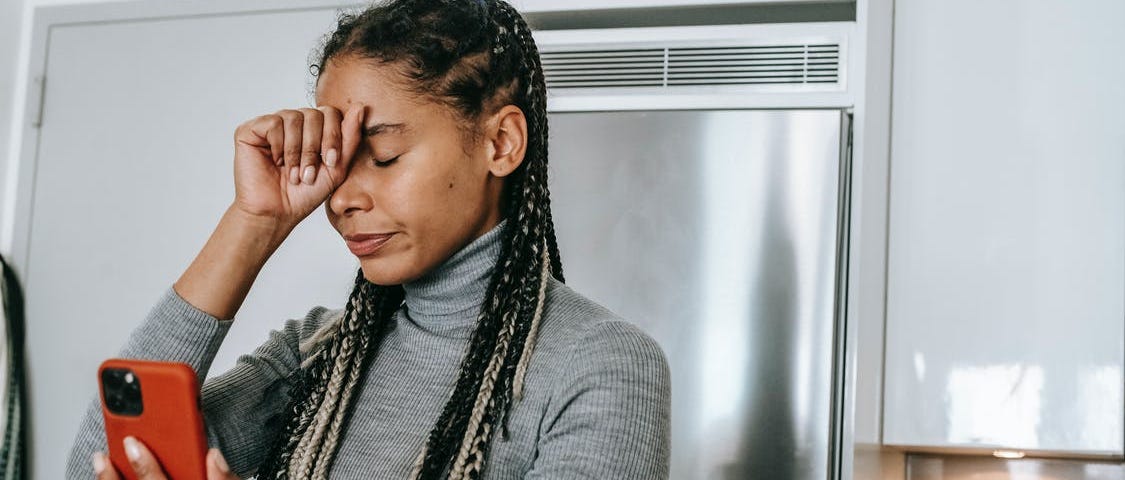 A frustrated woman holds a phone in her hand