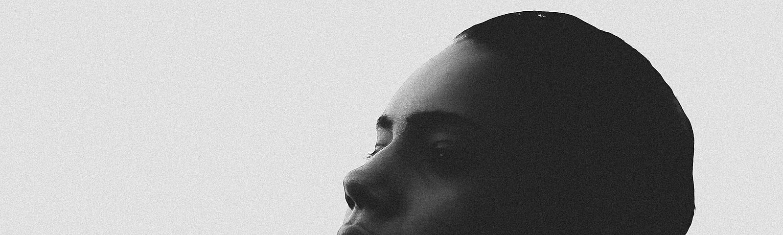 black and white picture, zoomed in on a woman’s head looking into distance.