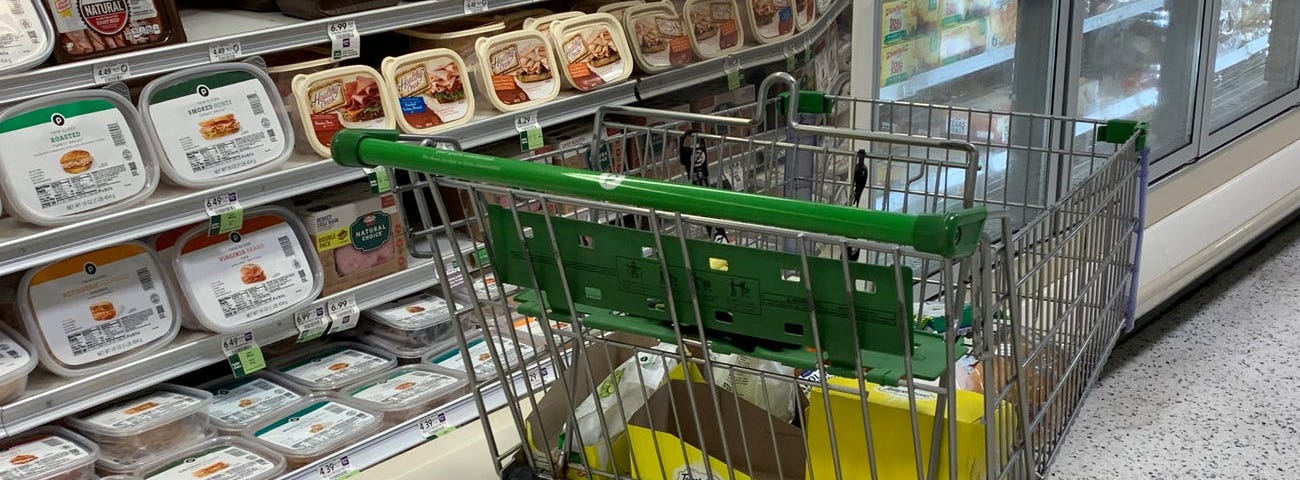 A shopping cart filled with items at a supermarket.