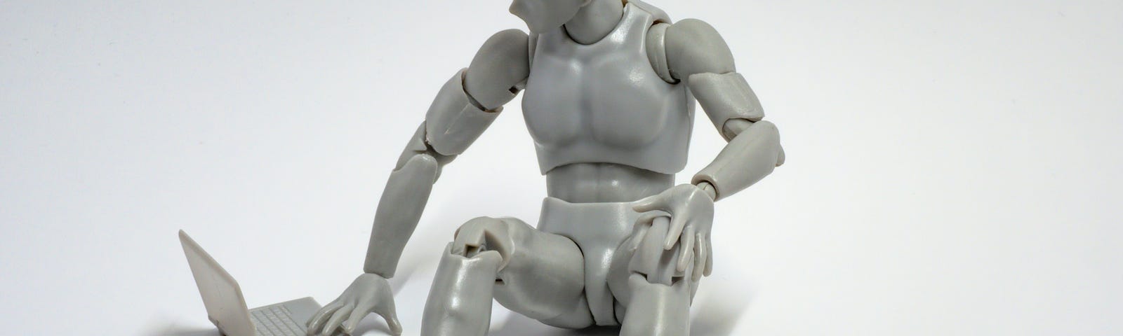 An image of a model of a robot using a model laptop