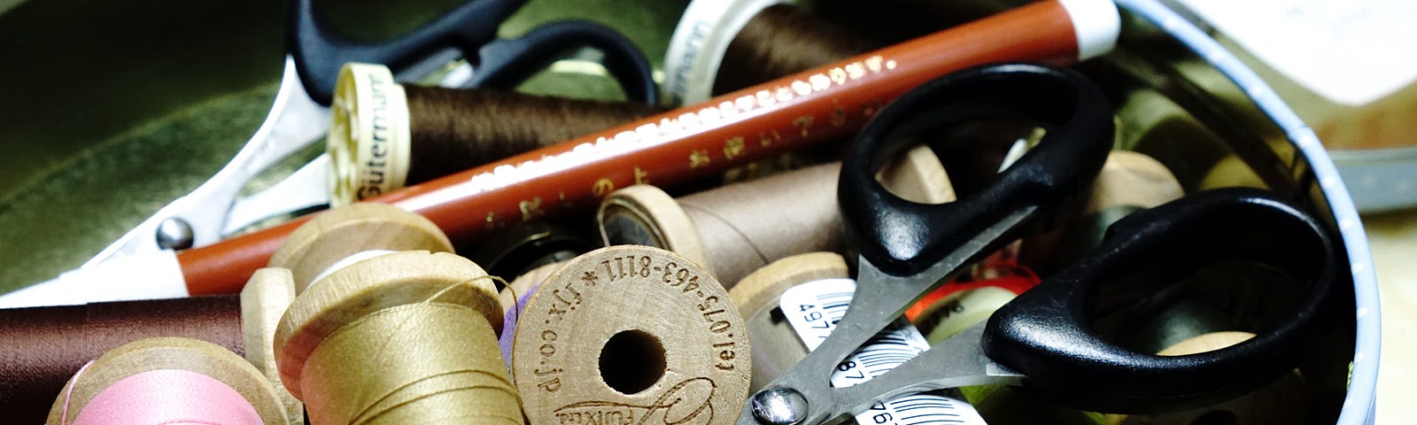 A sewing kit with neutral shades of thread, a pencil, and a good pair of scissors.