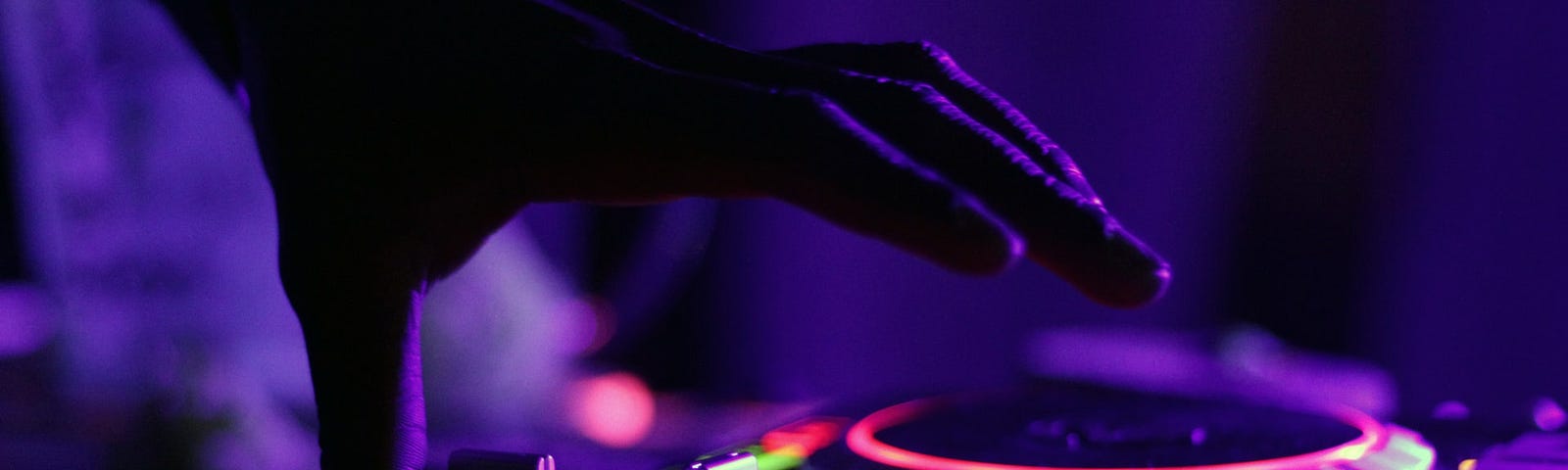 Person operating as a DJ, with hand’s on discs