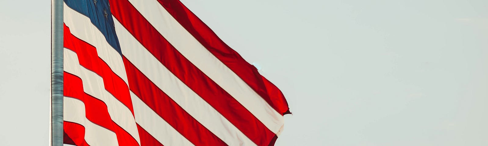 American flag blowing in the wind / Photo by James Balensiefen on Unsplash