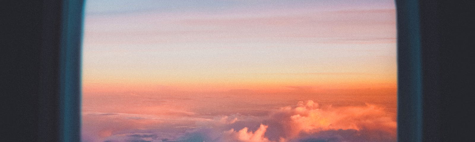 Plane window looking out at a sunrise