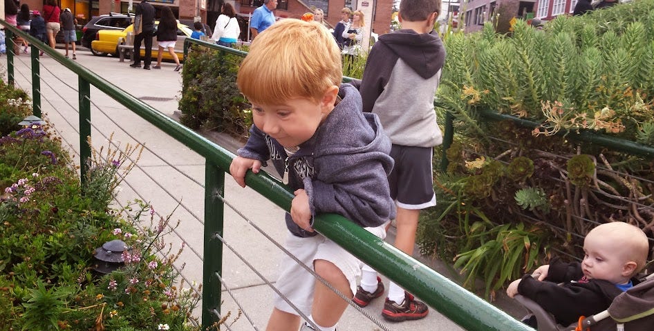 preschooler climbing a fence