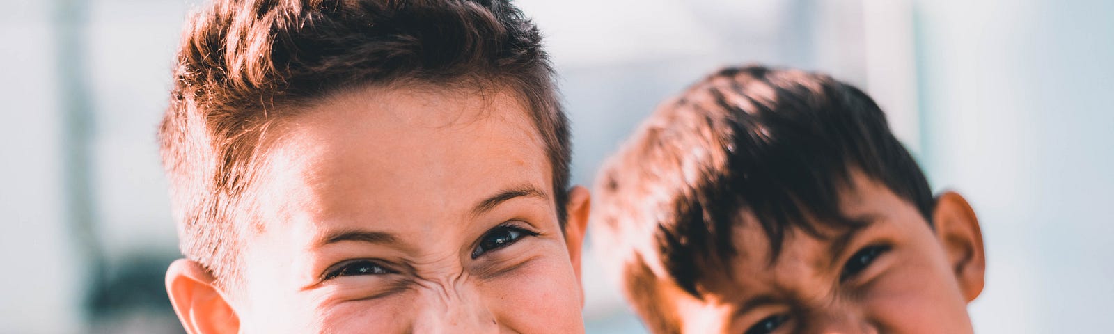 Two young boys making scrunched-up faces at the camera