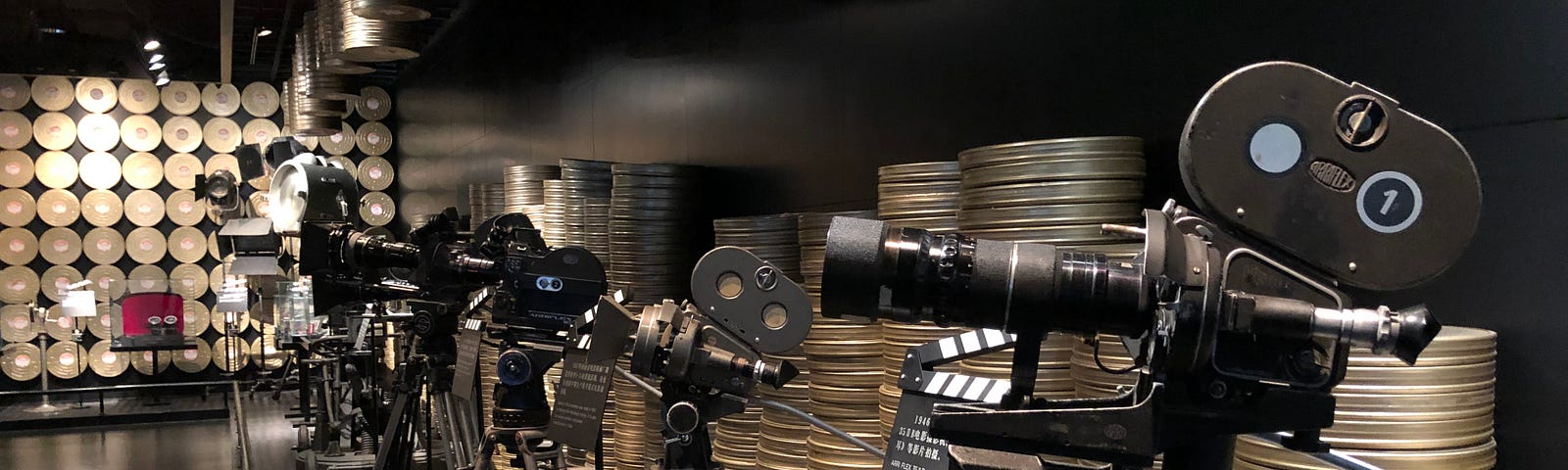 Movie cameras lined up along with film reels.