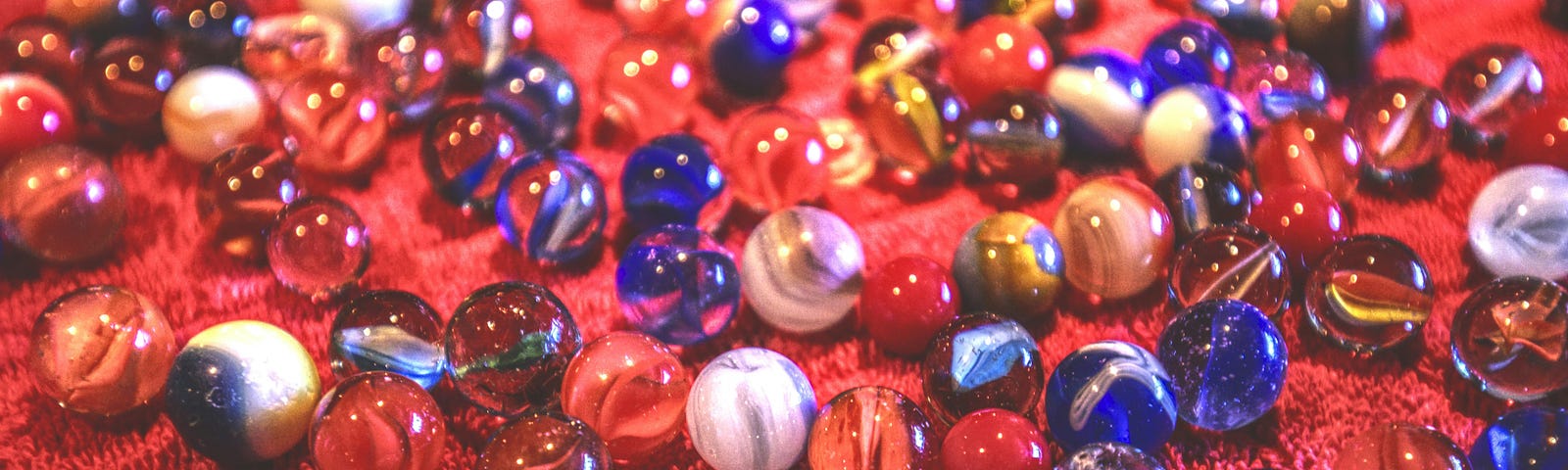 colored marbles on a red surface