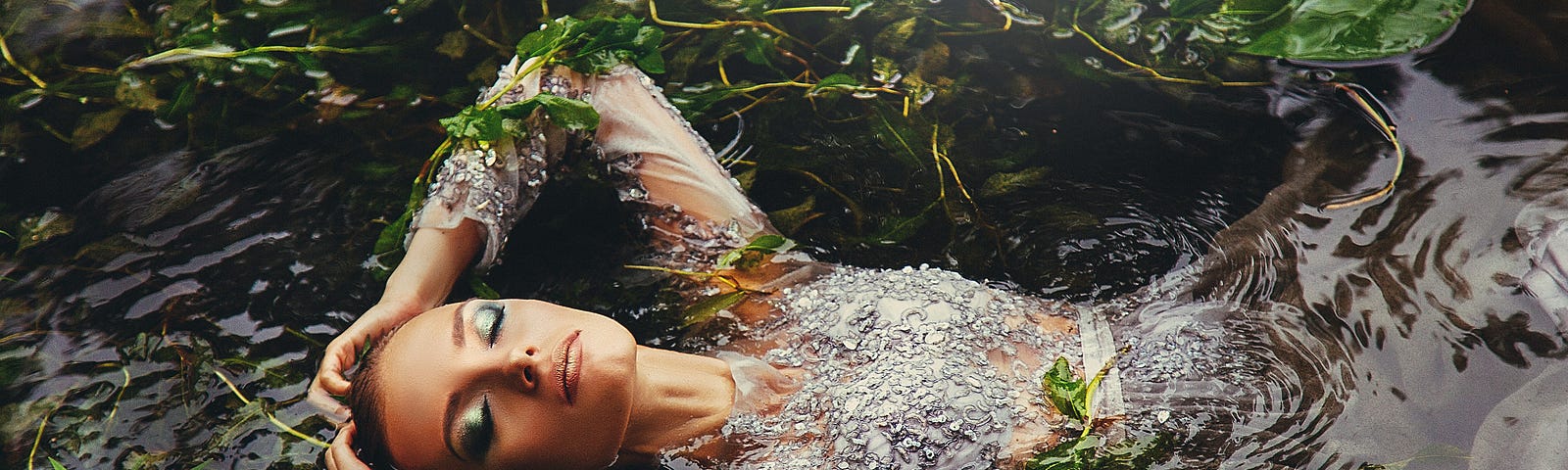 A woman floating in a lake surrounded by vegetation.