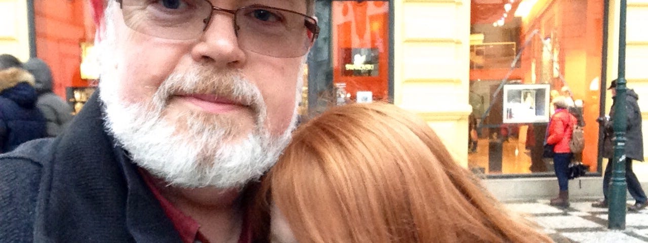 Color photo of a father and daughter hugging in Prague.