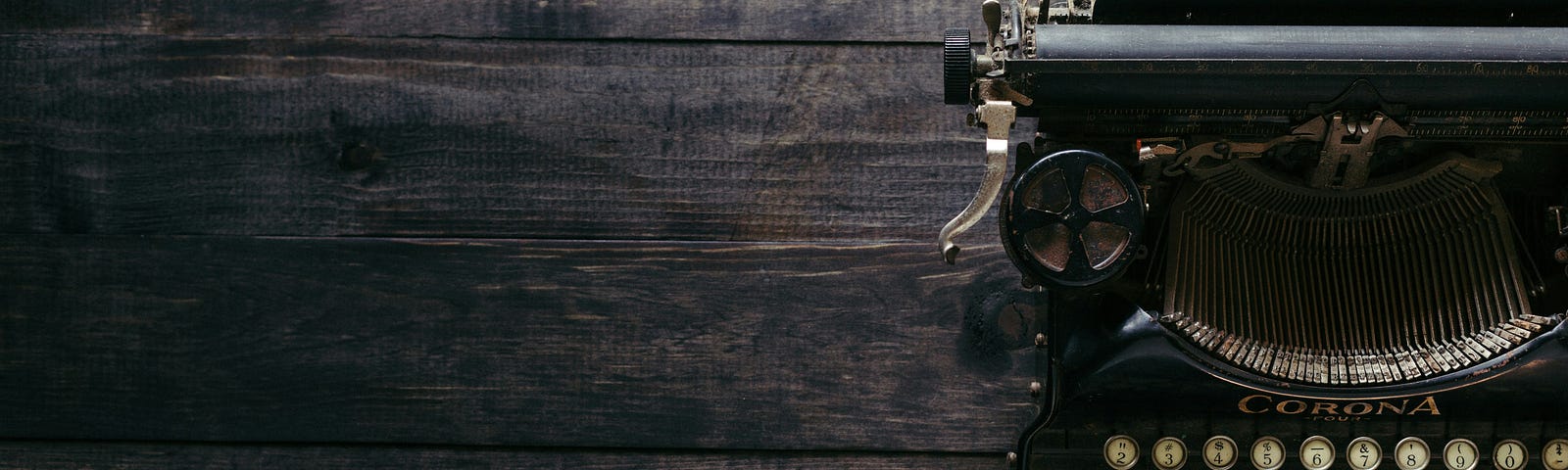 An antique typewriter sits on a wooden table