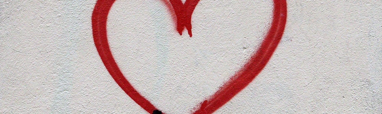 A spray painted drawing of a stick figure holding a love heart