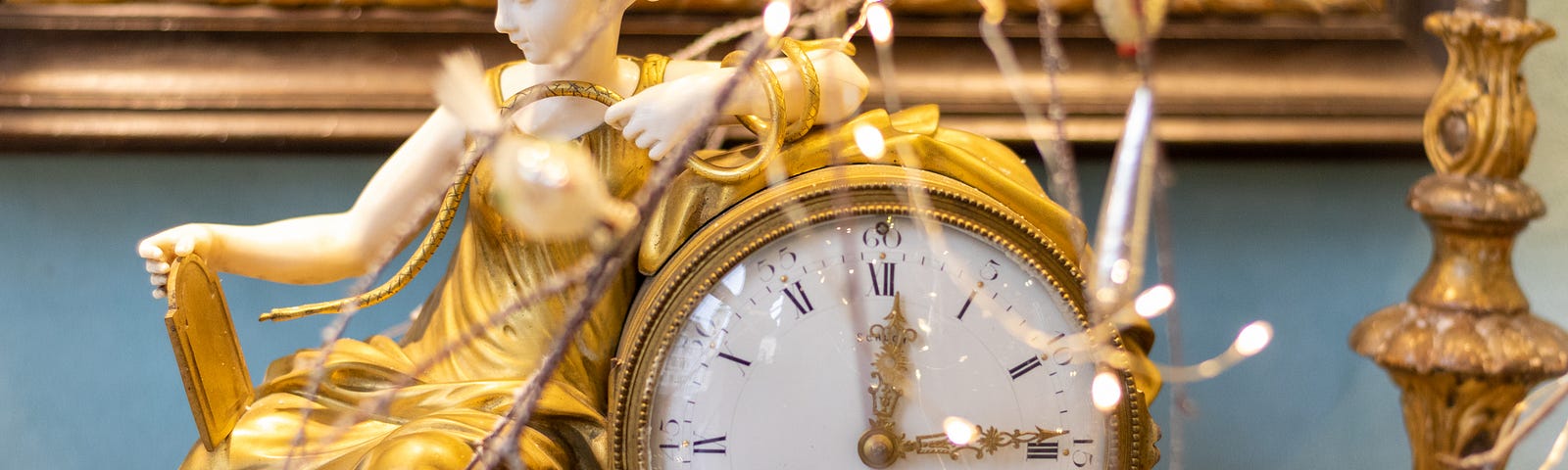 fancy gold clock with figure of a woman in gold gown