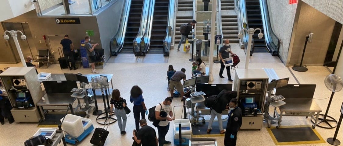 Passengers pass through TSA at JFK airport.