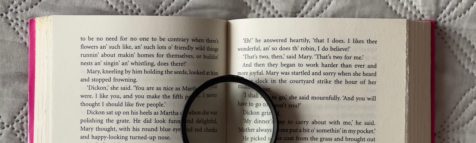An open book with a magnifying glass sitting on the text