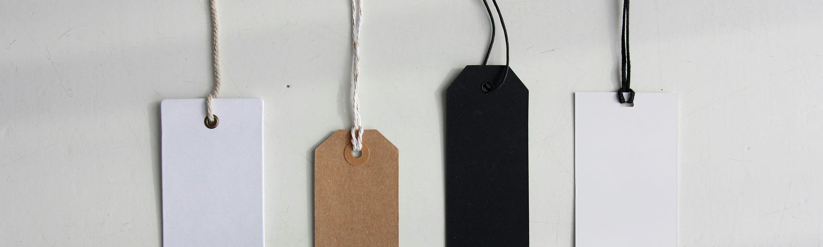 Photo of different sized and  coloured labels hanging down on a white background.
